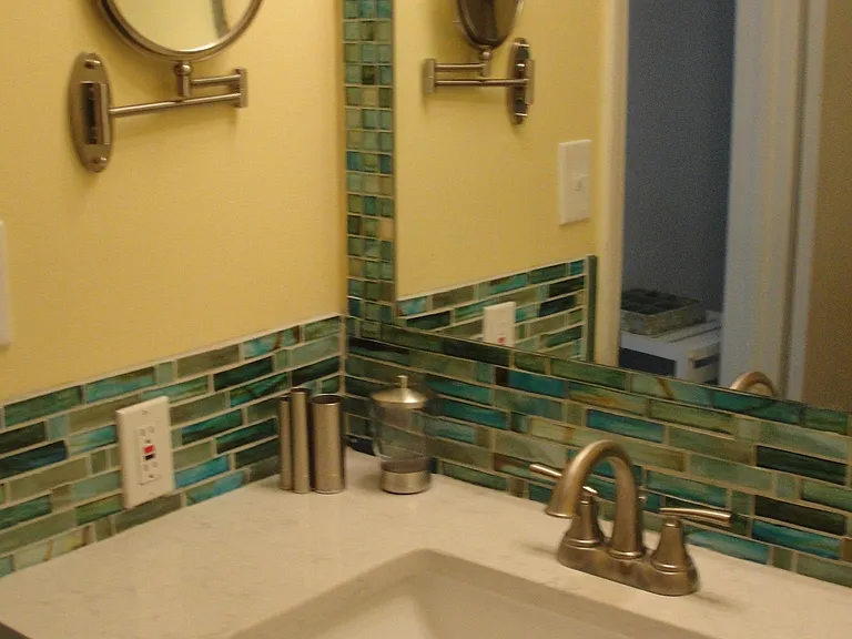 Upgraded bathroom with granite countertop and upgraded vanity. Vanity mirror and glass tile backsplash!