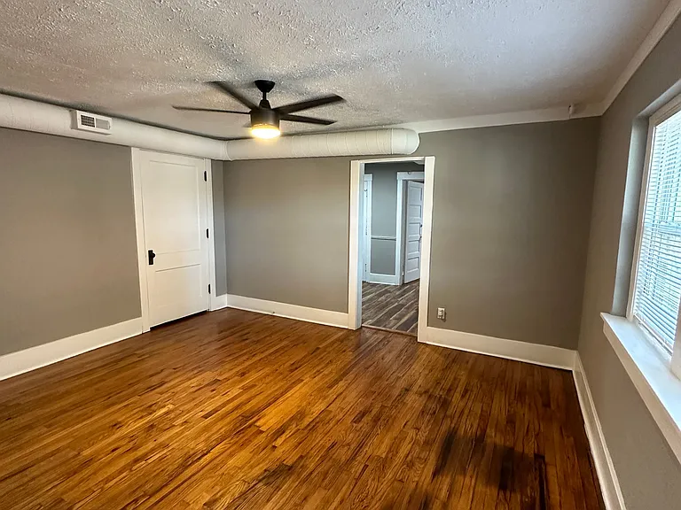 Ceiling fan and wood flooring in a living room at University Court.