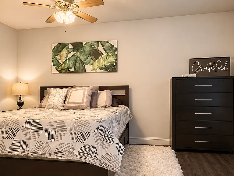 Downstairs bedroom (includes: queen-size bed with storage underneath, dresser, nightstand, also two bookcases with lots of books and other furniture off camera)