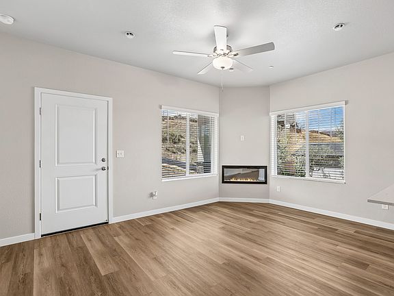 The family room is spacious with a ceiling fan and electric fireplace