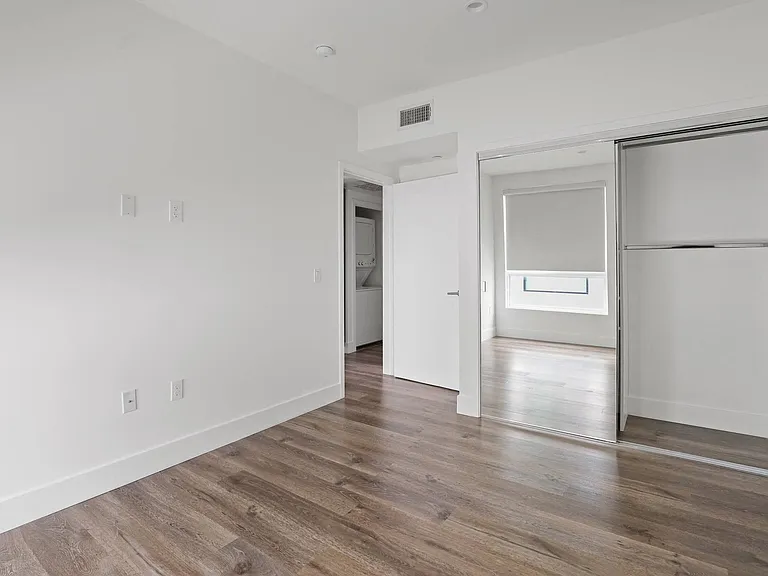 Bedroom with Mirrored Closet and Vinyl Flooring