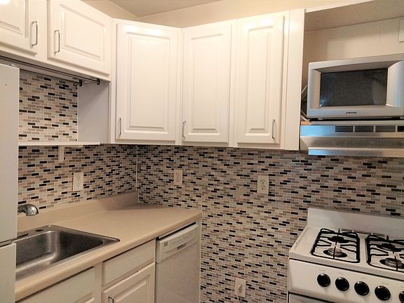 Kitchen with dishwasher, gas stove, microwave, fridge.