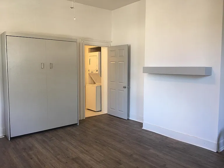 View to bathroom door and washer dryer. Queen sized Murphey bed is in the closed position. It is not functioning well and may need to be left down.