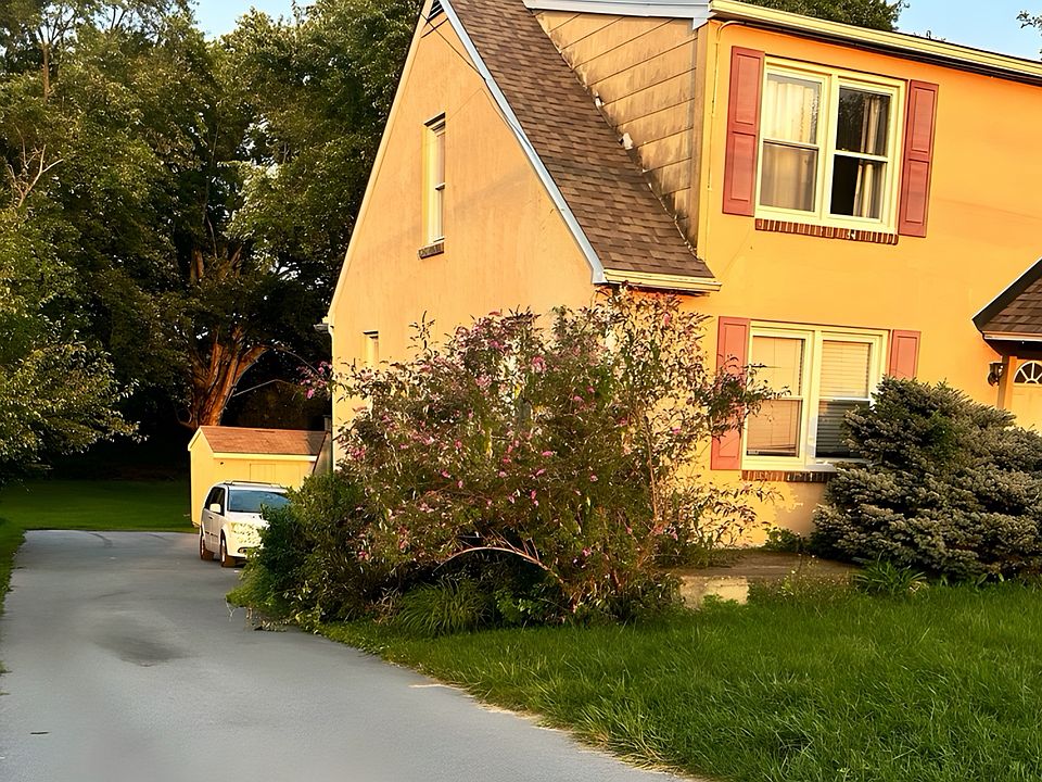 Charming three-story home with shared common-drive access and a beautifully green setting.