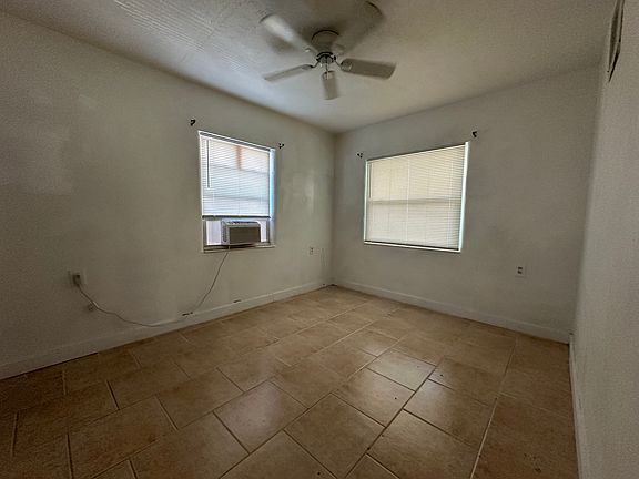 Main bedroom has ceiling fan, window AC, two windows, closet.