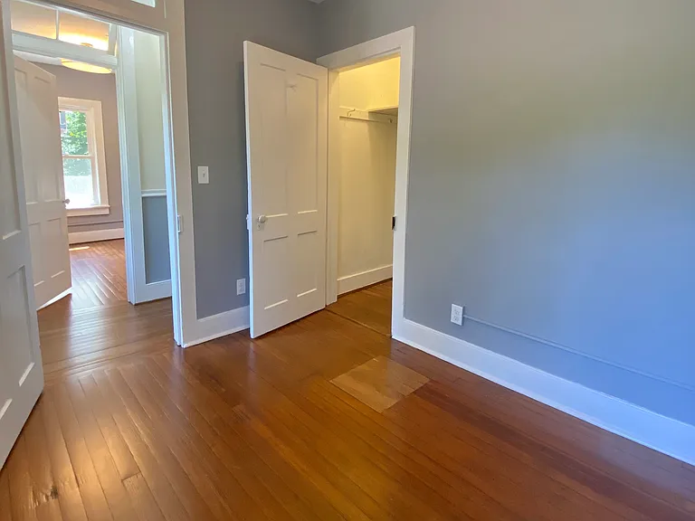 Comfortable bedroom with a closet, hardwood floors.