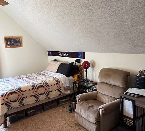 Bedroom with vaulted ceiling.