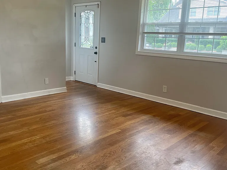View from back door. Open living room with hardwood floors and an entrance closet.