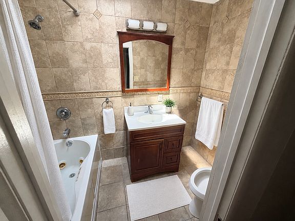 Virtually staged bathroom. Towels, bath mat, plant, and decor were digitally added for visualization; all permanent fixtures and the room's layout are unchanged.