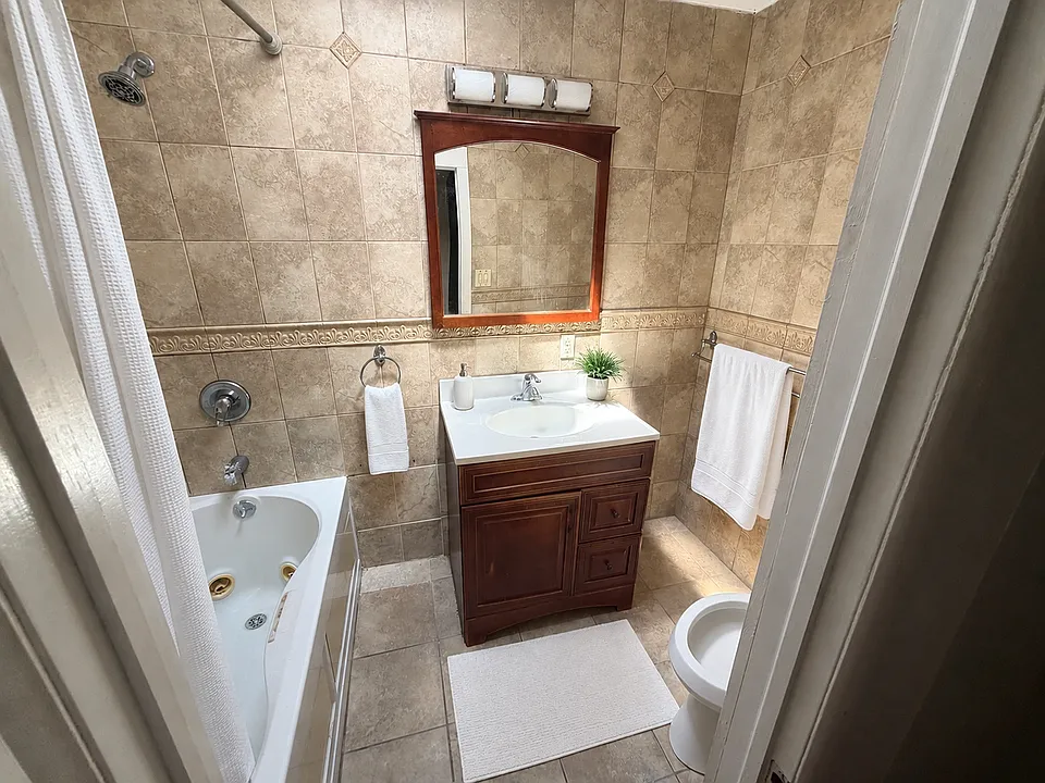 Virtually staged bathroom. Towels, bath mat, plant, and decor were digitally added for visualization; all permanent fixtures and the room's layout are unchanged.