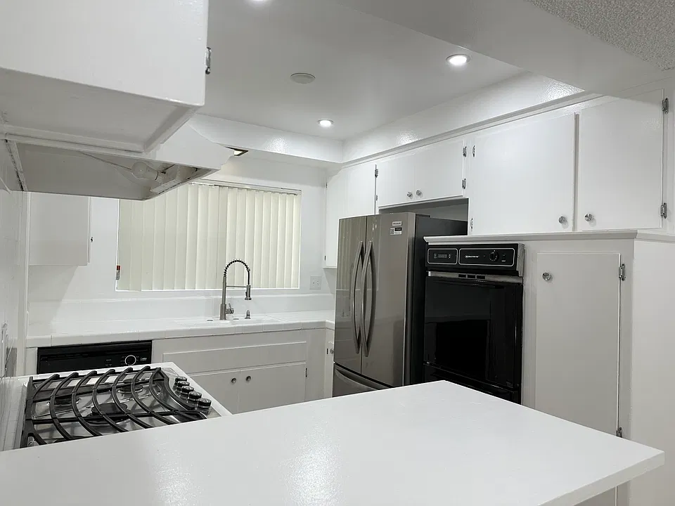 Kitchen has a dishwasher, refrigerator, gas stove top, and oven