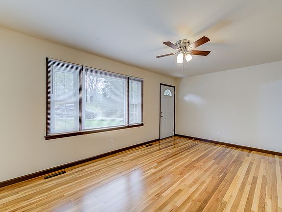 Living room with picture window and newly refinished hardwood flooring.