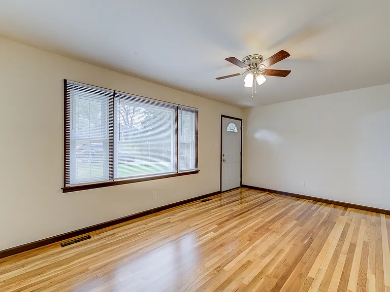 Living room with picture window and newly refinished hardwood flooring.