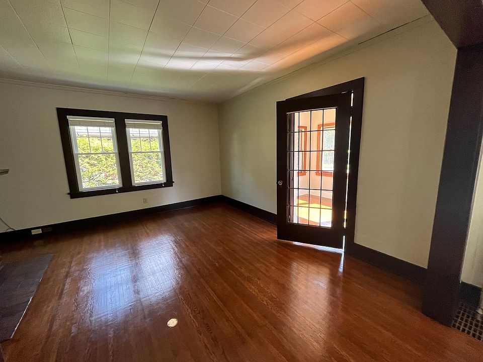 Living room with leaded glass door leading to porch. Living room is 14' x 14'. Note: This and all following images are current. Images taken on or after August 2023.