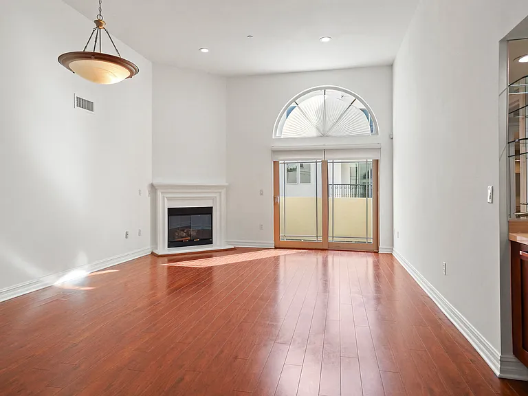 Living Room Space with a Wet Bar, Fireplace, and Balcony