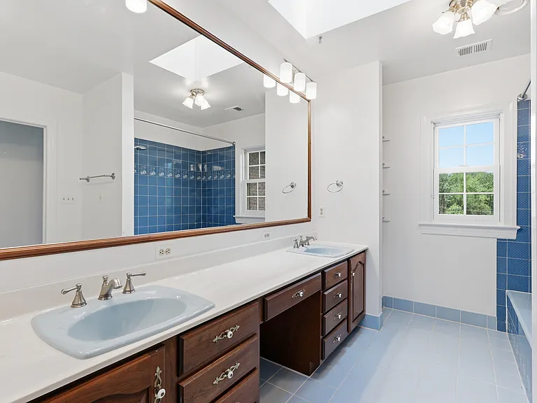 Secondary bath with double sinks and tub.