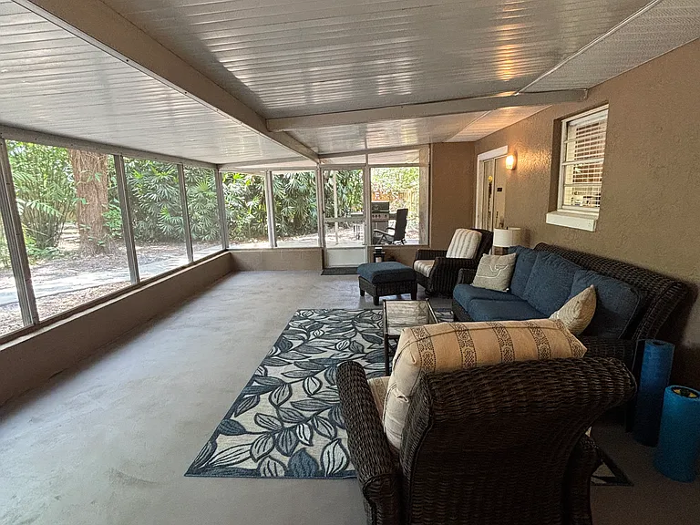 Screened in patio overlooking the large back yard with huge oak trees.