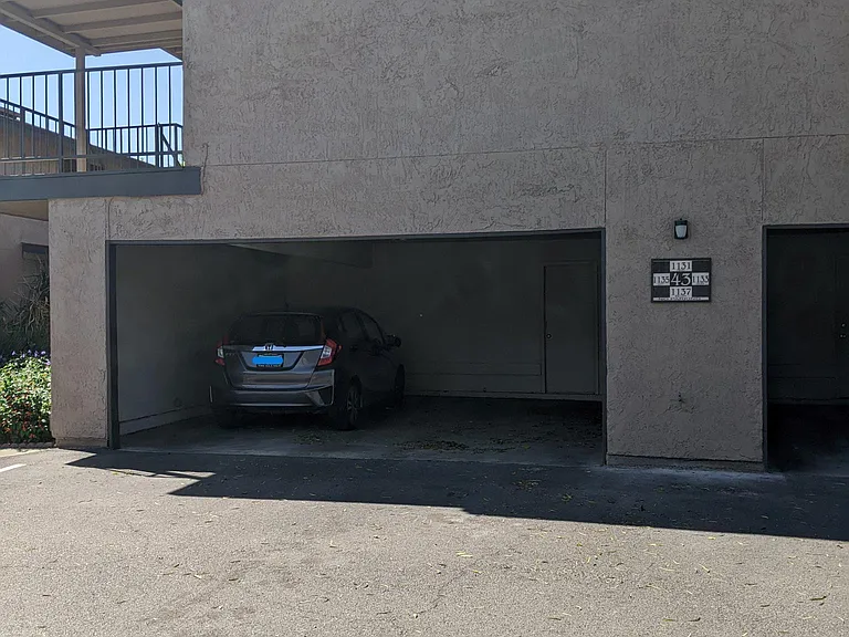 Empty spot to the right of the parked car is this unit's space for parking