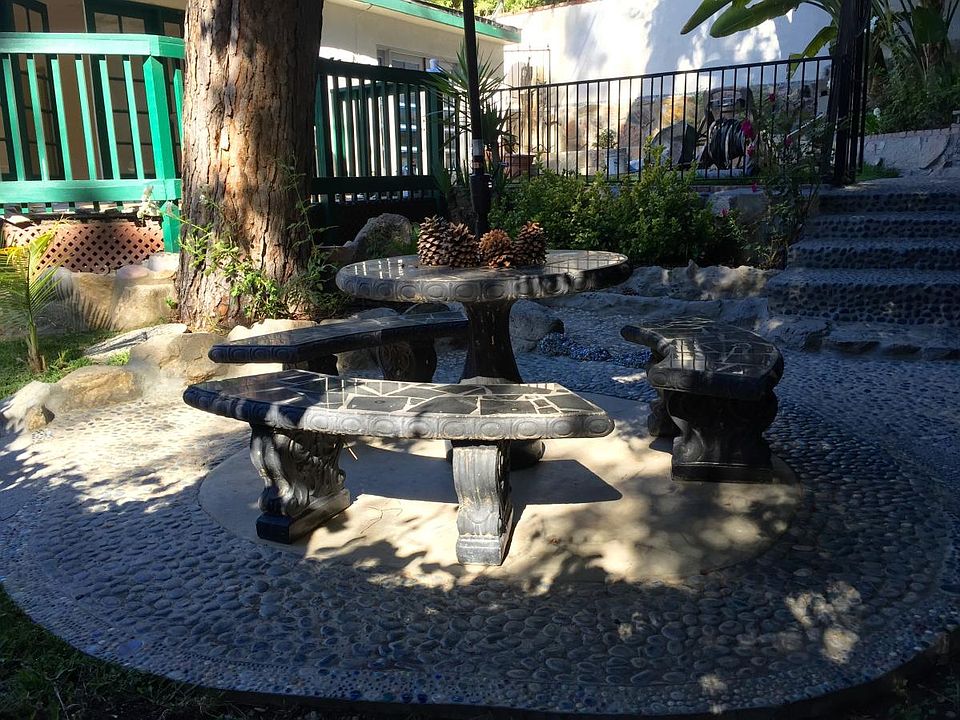 Lower patio with decorative rocks. The table does have a green umbrella.