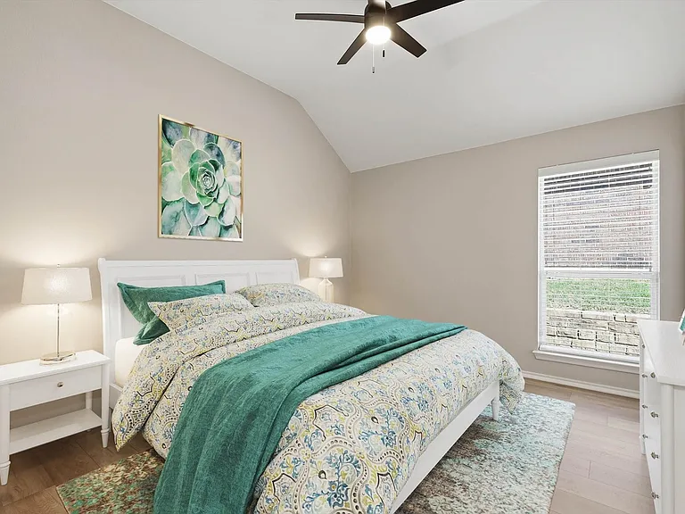 Bedroom featuring a vaulted ceiling, wood-finish flooring, and a ceiling fan with integrated lighting