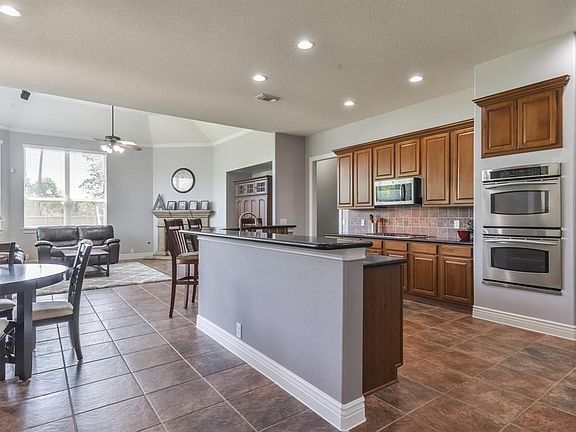 Kitchen boasts breakfast bar, stainless steel appliances, and abundant prep and storage space.