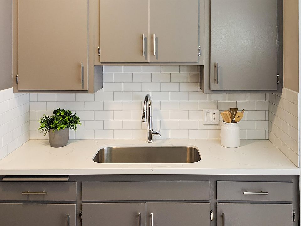 Updated quartz countertop, tile backsplash, single basin sink and faucet