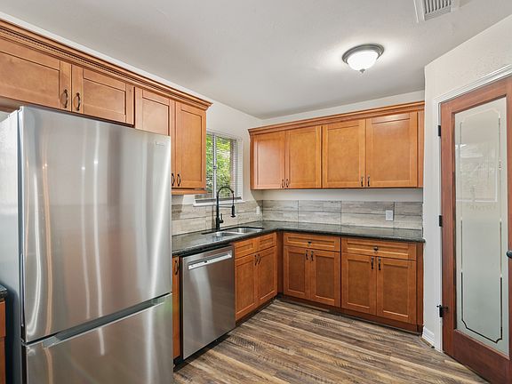 This bright and inviting kitchen features warm custom cabinetry and sleek granite countertops