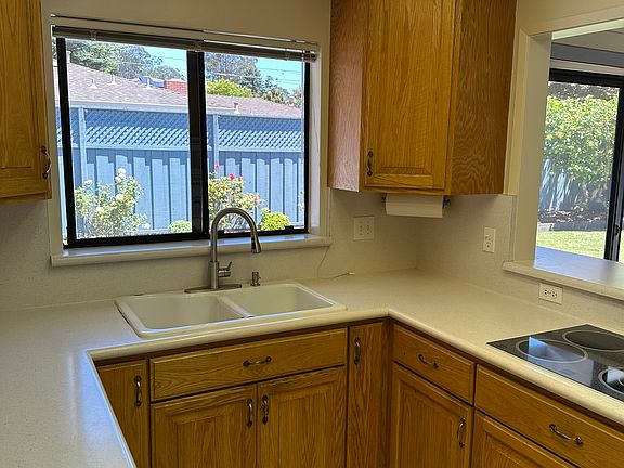 Updated large kitchen with newer appliances and a view of the private backyard