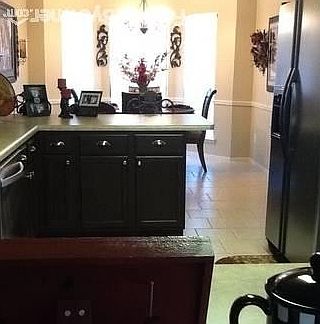 Kitchen with stainless steel appliances and dining area with bay window.