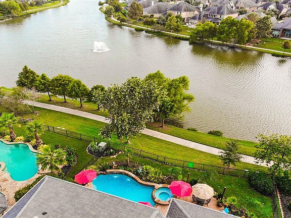 Behind the home is the lake with its paved walking trail, landscaped tree lined walkway with great view of the fountain as you relax in the heated spa and splash in the pool.
