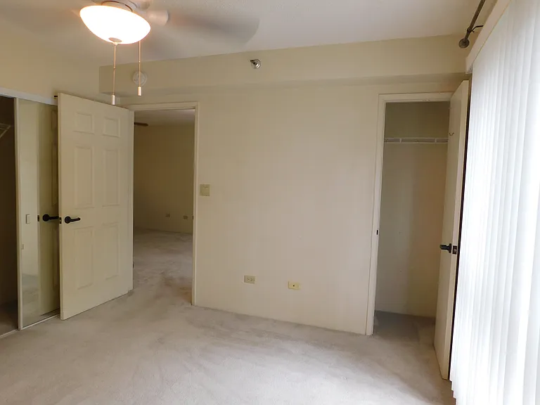 Primary bedroom, two closets. Door to living/dining.