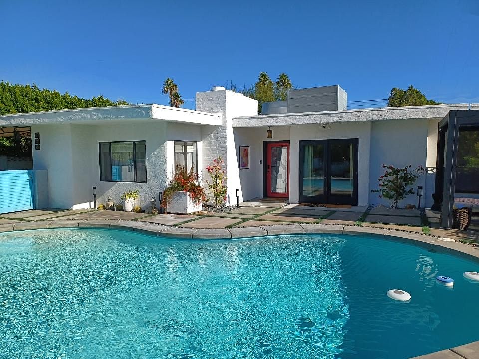 Front of home facing east; featuring private kidney shaped pool and pergola with screens for shade.
