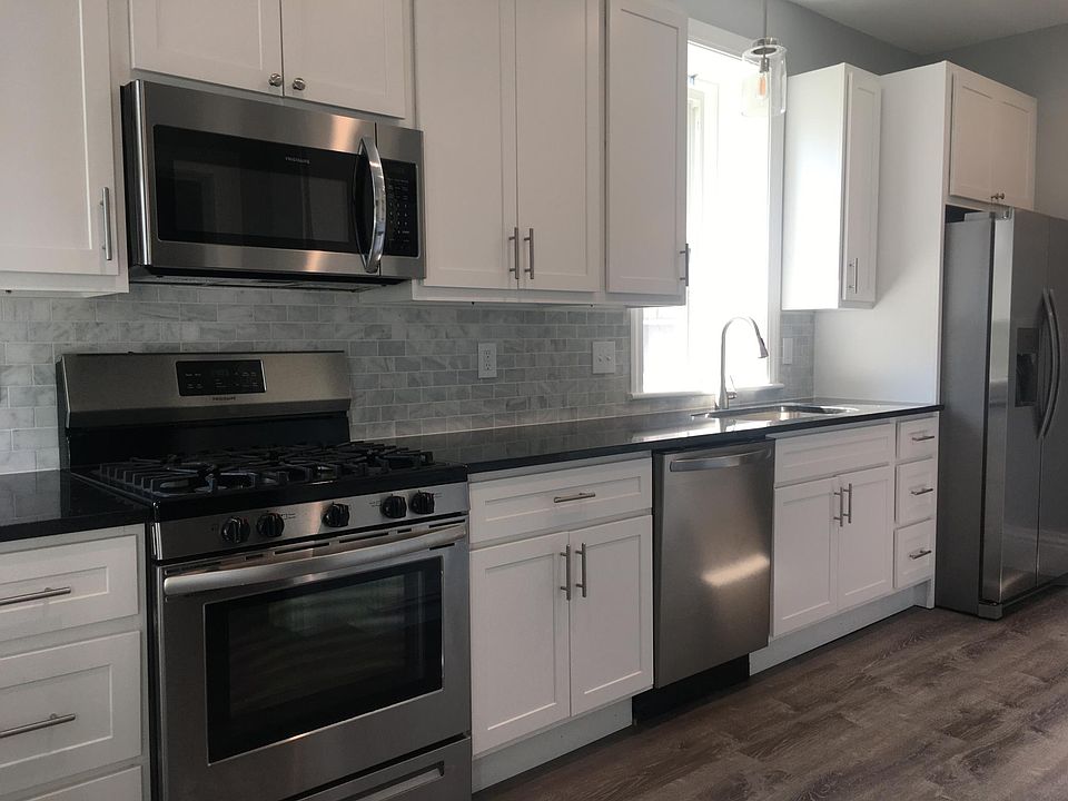 Bright kitchen with stainless appliances, granite counters and marble backsplash