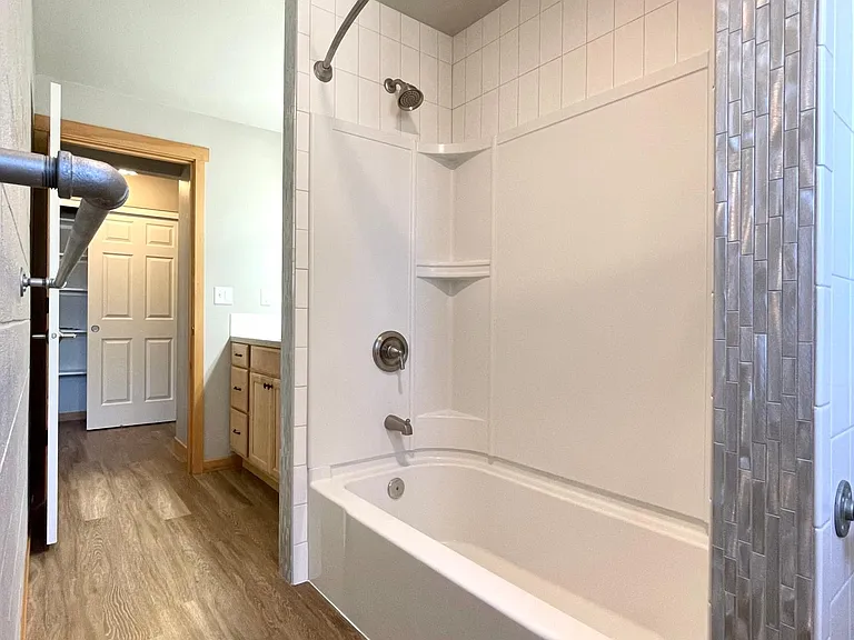 Easy to care for tile throughout this bathroom. Check out the brushed metal tile trim!