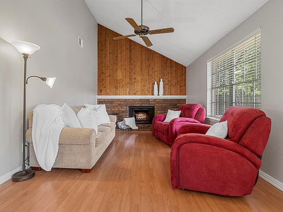 Just across the way you'll find the family room with a beautiful brick-framed fireplace and a stunning wood panel accent wall. Wood laminate floors complete the look. Gather, lounge, converse.