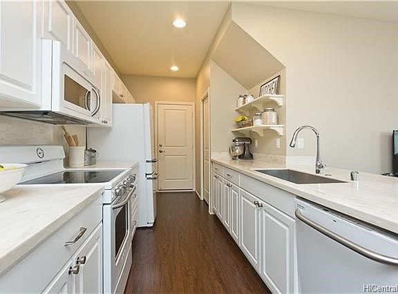 Open galley kitchen, upgraded counter tops, ample cabinets and a very nice panty. Easy access to garage.