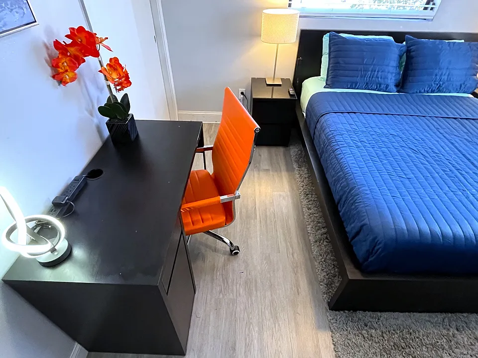 Room 2 features: Queen bed, dual night stands, table lamps, ceiling fan, mini fridge, desk, 65in TV