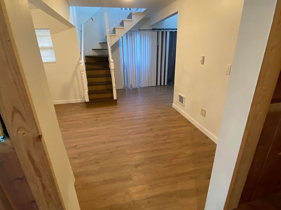 Open main-level area with updated flooring and bright light, offering flexible space for living, dining, or a creative layout that fits your style