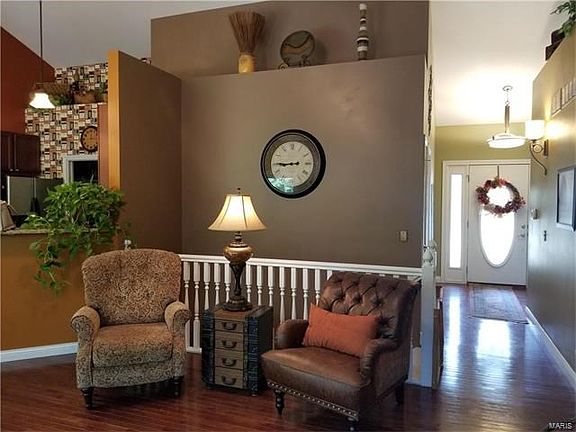 Vaulted great room with wood floors & plant shelves.
