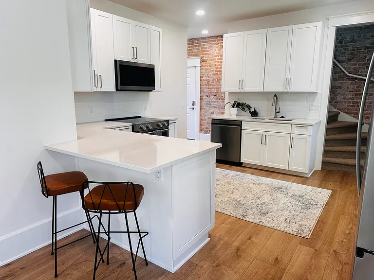 Renovated kitchen with quartz countertops and new appliances.