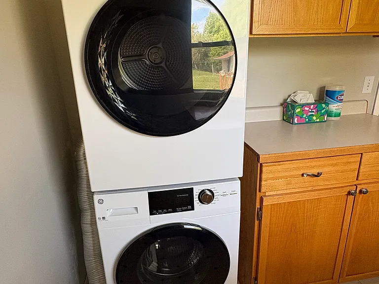 New stack washer & dryer in Utility Room, oak cabinetry for storage
