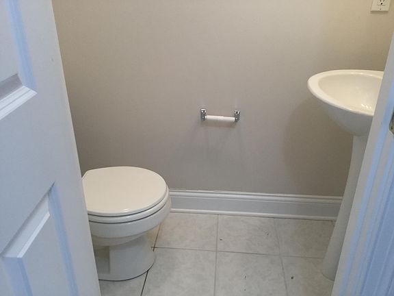 1/2 Bath located in Foyer directly across from Garage Entrance