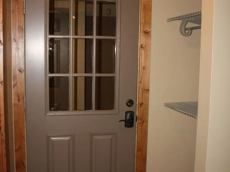Entrance to apartment with storage on right. Washer and dryer just outside door to right, along with additional locked storage room.