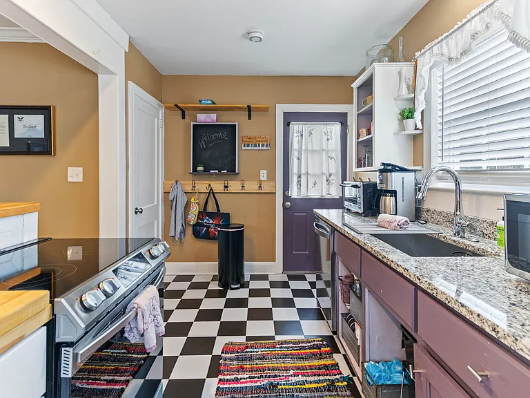 Kitchen at Hunsucker's was completely remodeled in 2023 and features stainless appliances and checkerboard tile floor all within walking distance of Downtown and Cone Hospital