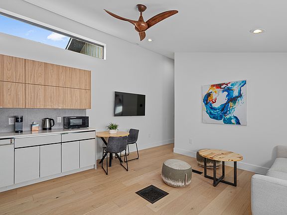kitchen and living room with a wall hung TV.