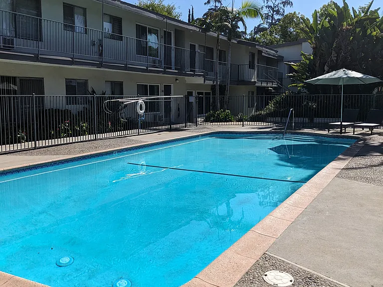 Swimming pool and apartments in gated courtyard of Los Robles Apartments in Pasadena, California.