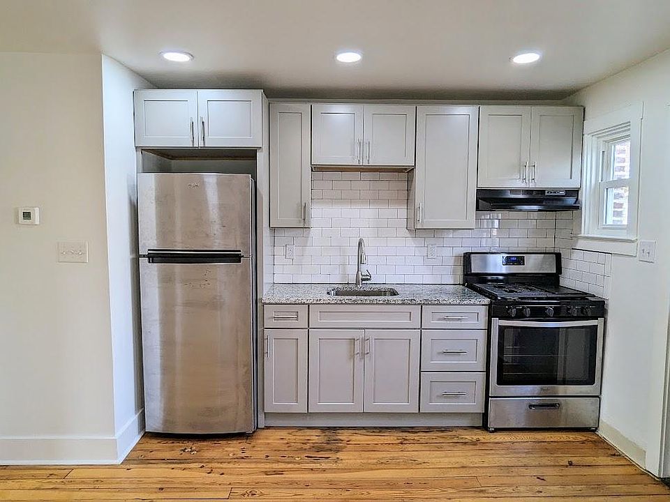 Kitchen with granite countertops, tile backsplash, gas stove and stainless appliances.