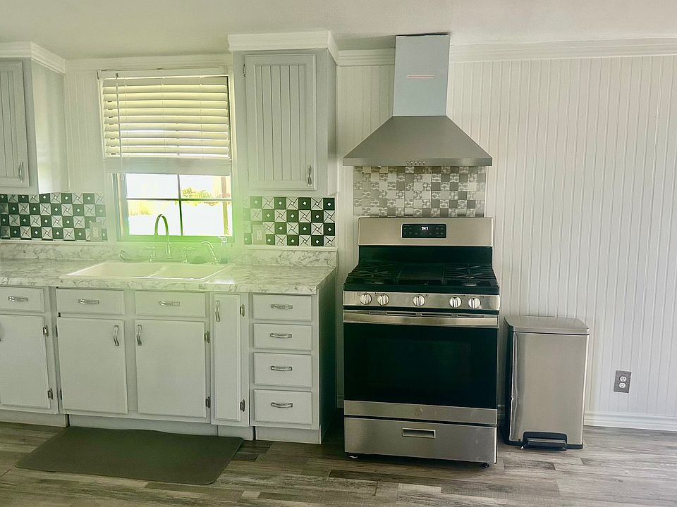 Kitchen with vent hood. Stainless gas range.