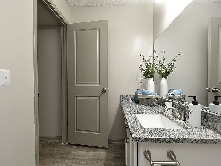 Bright bathroom with granite counters and bathtub