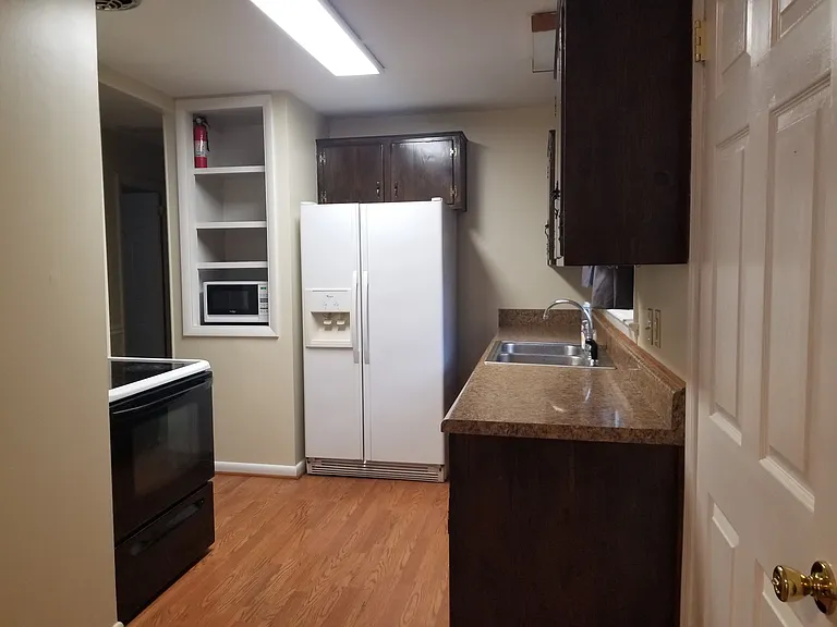 Refrigerator with ice maker.
Microwave on shelf to left of refrigerator.